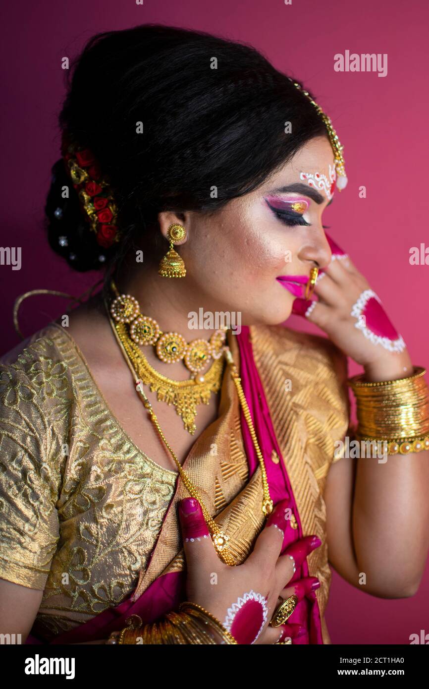 ritratto nuziale di signora indiana che indossa tradizionale saree e oro gioielli Foto Stock