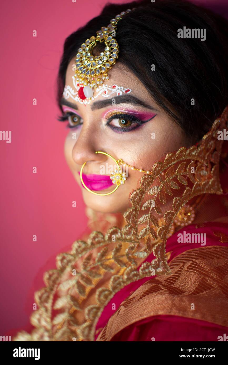 Sposa indiana vestita in rosso indù tradizionale abiti da sposa sari  ricamato con gioielli in oro Foto stock - Alamy