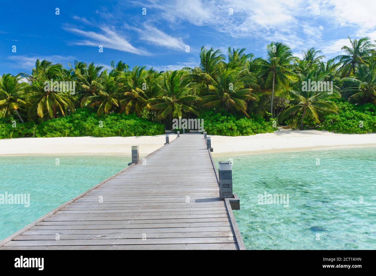 Tropical Maldivian Paradise - un molo che conduce ad un bellissimo atollo tropicale hiden nell'azzurro oceano Indiano. Foto Stock
