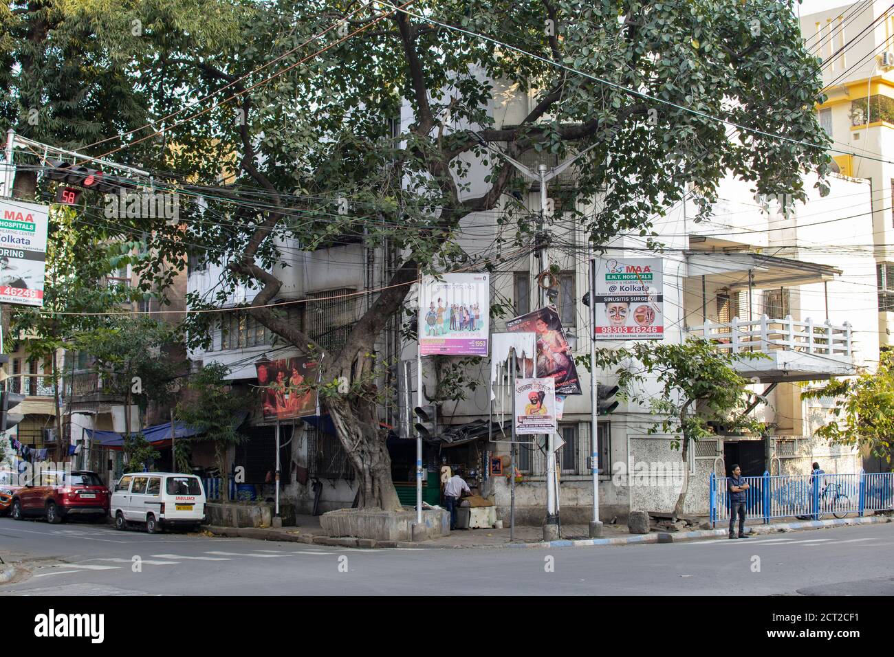 Kolkata, India - 1 febbraio 2020: Un angolo di strada locale con auto parcheggiate e tre uomini non identificati, ma senza traffico in strada Foto Stock