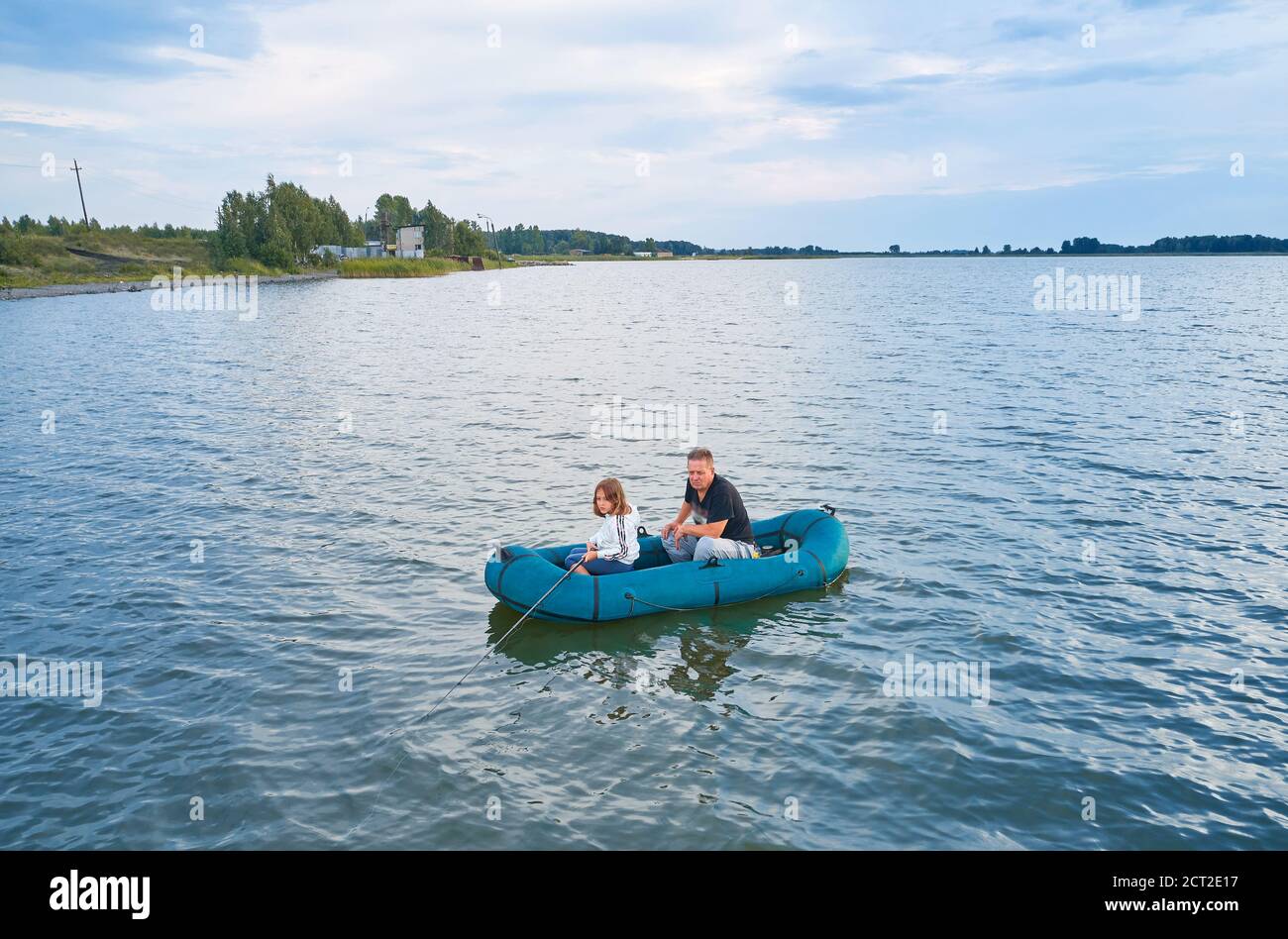 Nipote e nonno che pescano da una barca Foto Stock