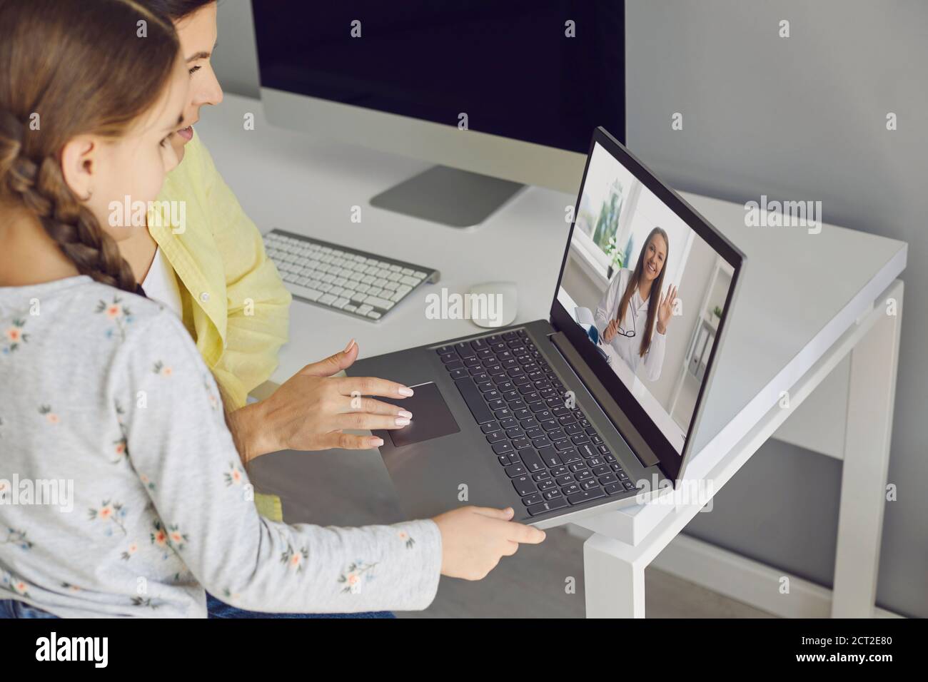 Madre e figlia che fanno una videochiamata al medico Foto Stock