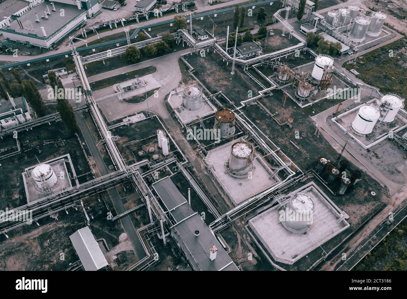 Sfondo paesaggio industriale scuro dall'alto. Stabilimento petrolchimico con tubazioni e serbatoi in acciaio, vista aerea. Foto Stock