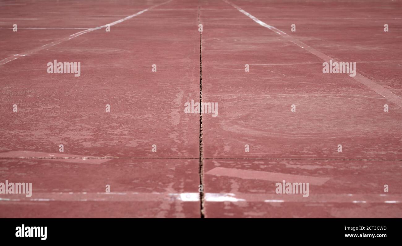 dettaglio di alcune linee bianche e gialle dipinte su a. campo sportivo marrone Foto Stock