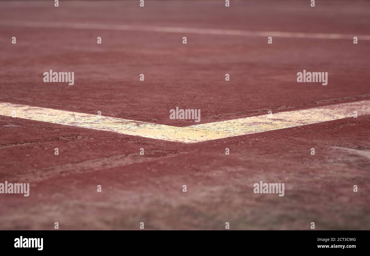 dettaglio di alcune linee bianche e gialle dipinte su a. campo sportivo marrone Foto Stock
