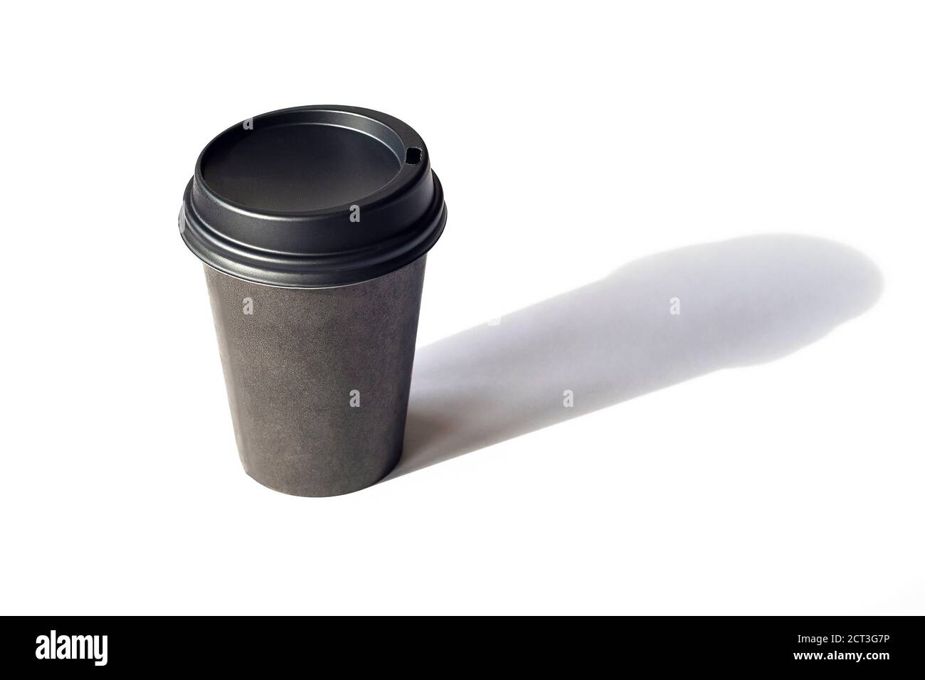 Tazza da caffè monouso su tavolo bianco, ombre nitide. Isolato su sfondo bianco Foto Stock