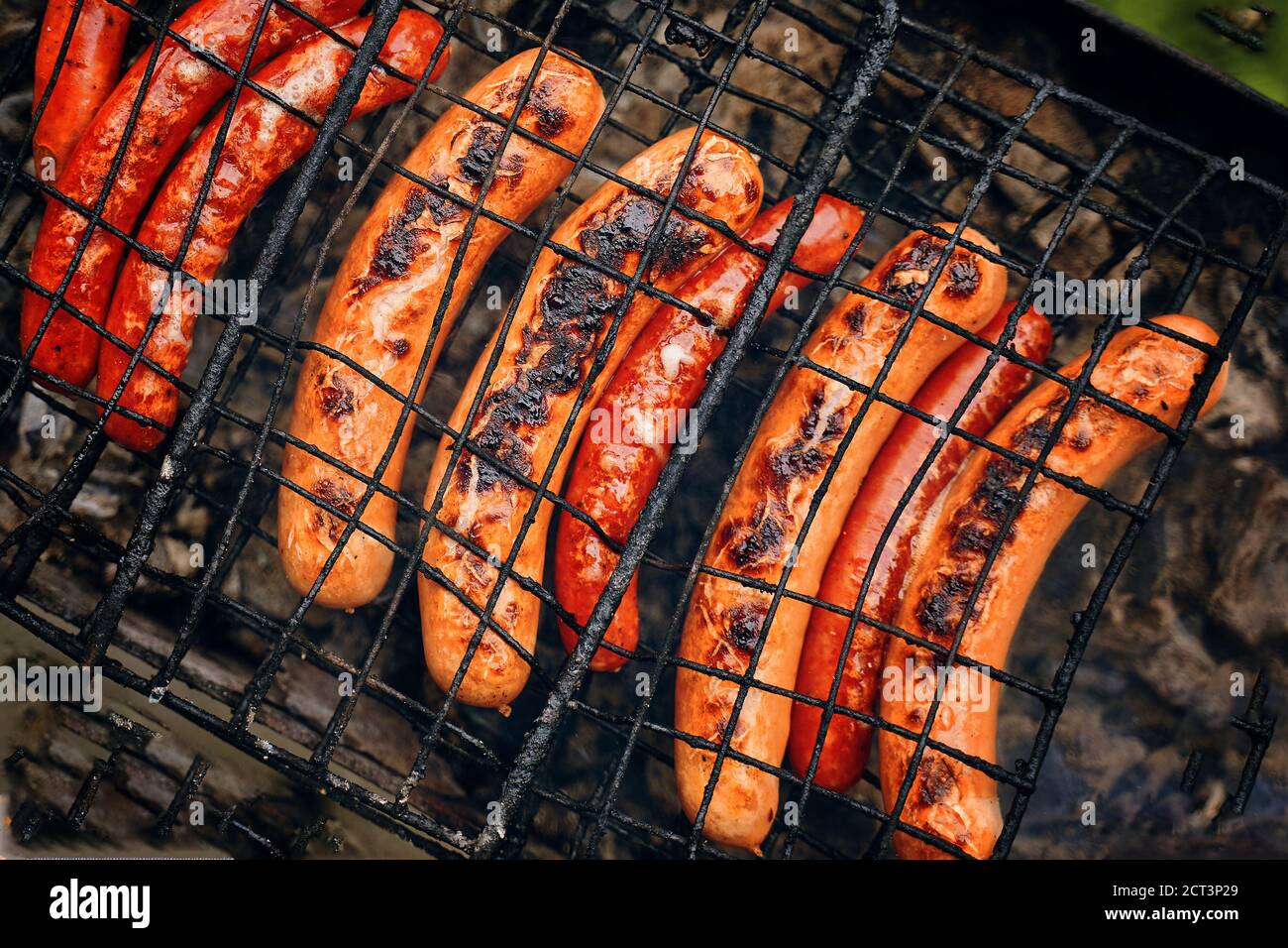 Barbecue con salsicce ardenti hot dog sulla griglia picnic all'aperto preparazione di piatti caldi da servire in una fiera locale all'aperto sul picnic. Vista dall'alto Foto Stock