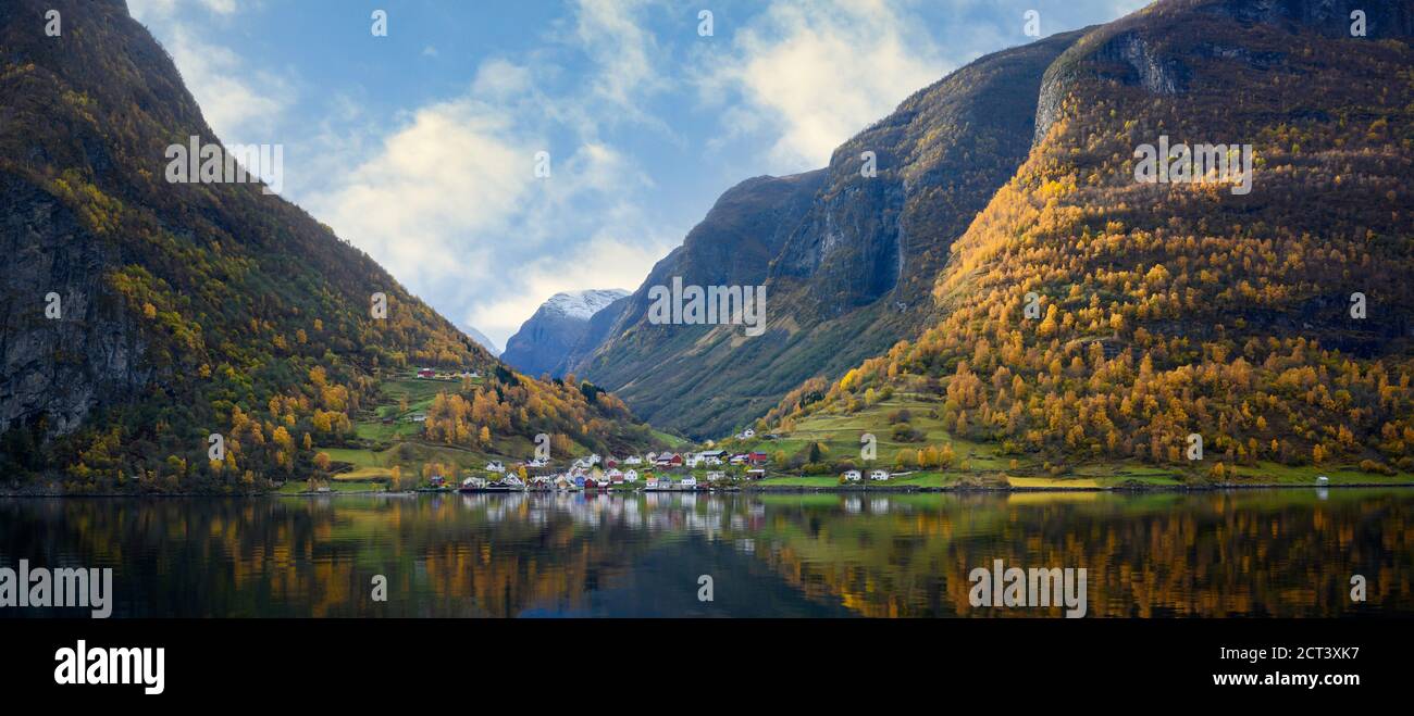 Panoramica il villaggio di Undredal è un piccolo villaggio sul fiordo. Aurlandsfjord la costa occidentale della Norvegia, le alte montagne e i villaggi si riflettono nel wate Foto Stock