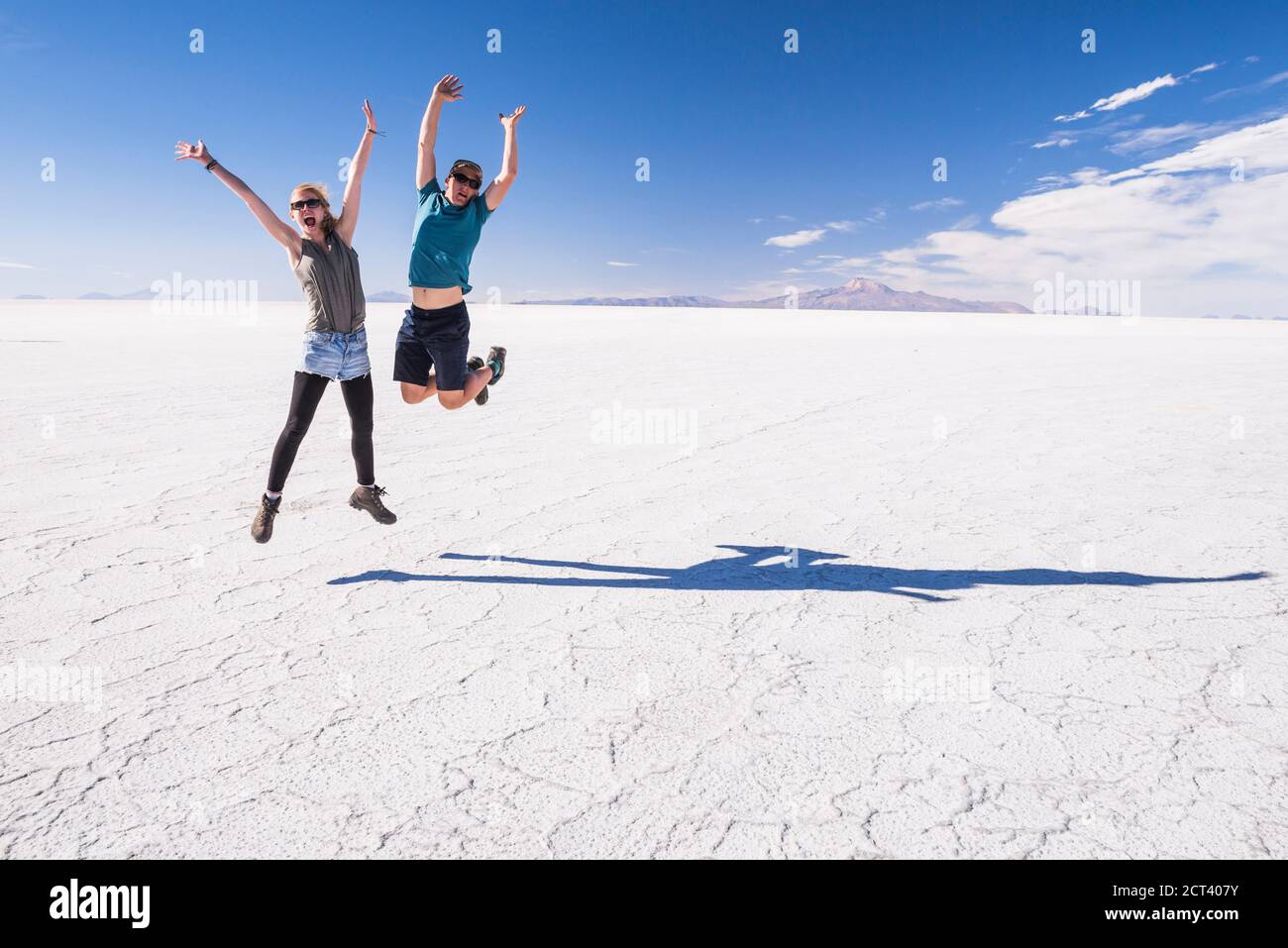 Giovane coppia turistica in vacanza mentre si viaggia in un anno di gap, sperimentando l'incredibile e unico paesaggio di Uyuni Salt Flats (Salar de Uyuni), Uyuni, Bolivia, Sud America Foto Stock