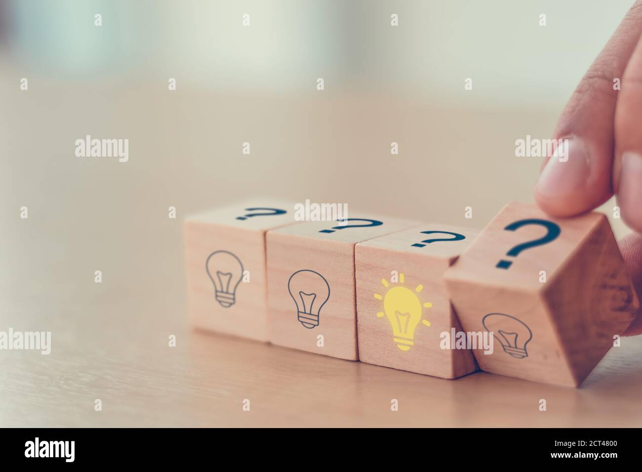 Concetto creativo di idea. Uomo a mano flip blocco cubo di legno forma punto interrogativo simbolo a destra lampadina simbolo. stile vintage Foto Stock