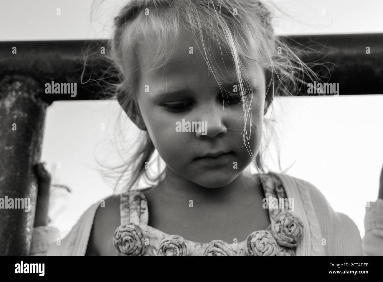 Primo piano ritratto in bianco e nero di carino risentito e triste bambino caucasico. Emozioni sincere dei bambini. Momenti di infanzia. Bambino in natura. Foto Stock