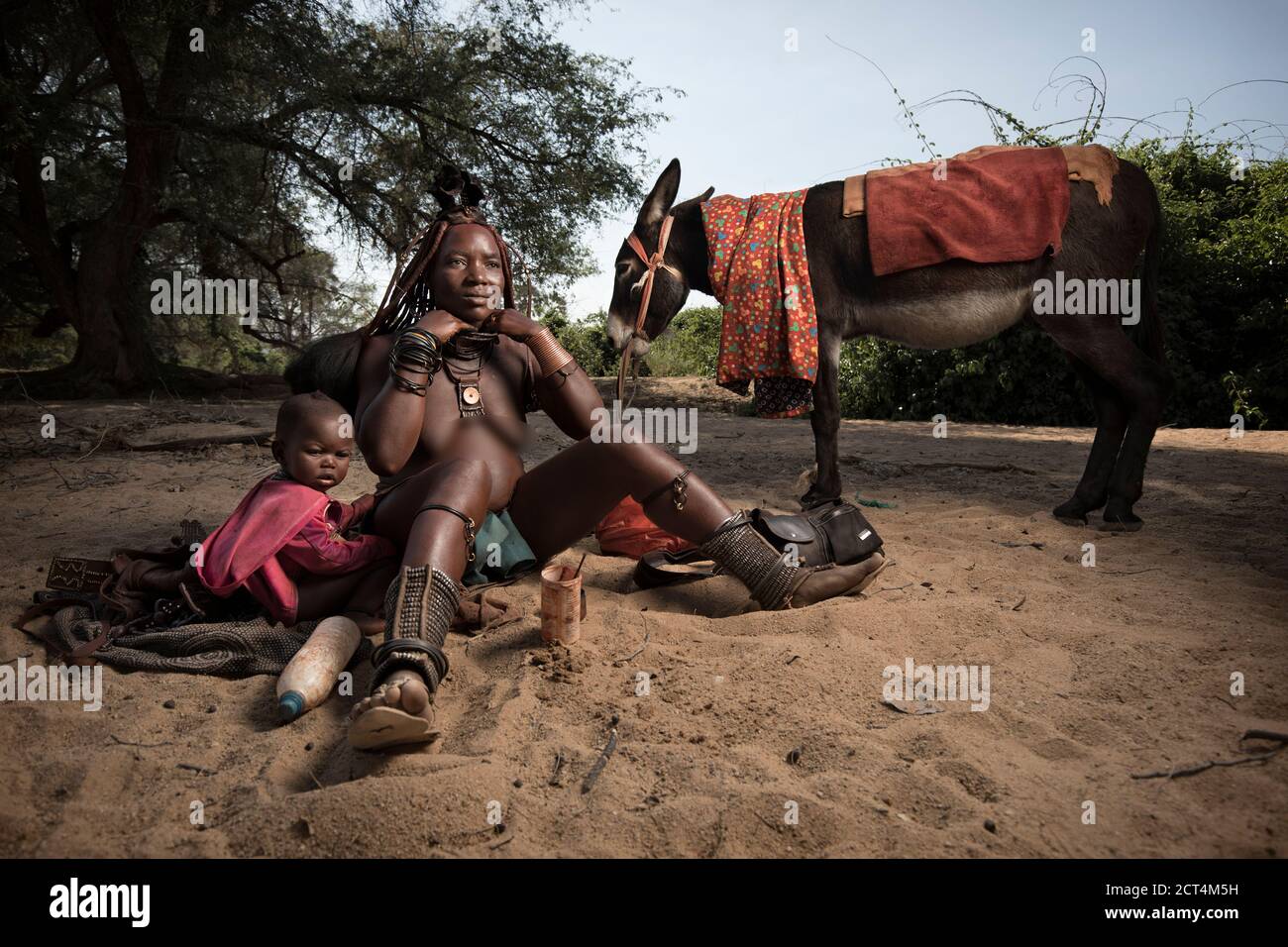 Una donna Himba si prepara in un letto di fiume, Namibia. Foto Stock