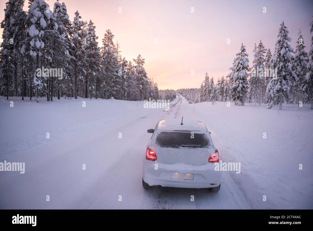 Auto che guida su strade ghiacciate innevate su una strada Viaggio durante il viaggio in Lapponia all'interno del Circolo polare Artico in Finlandia Foto Stock