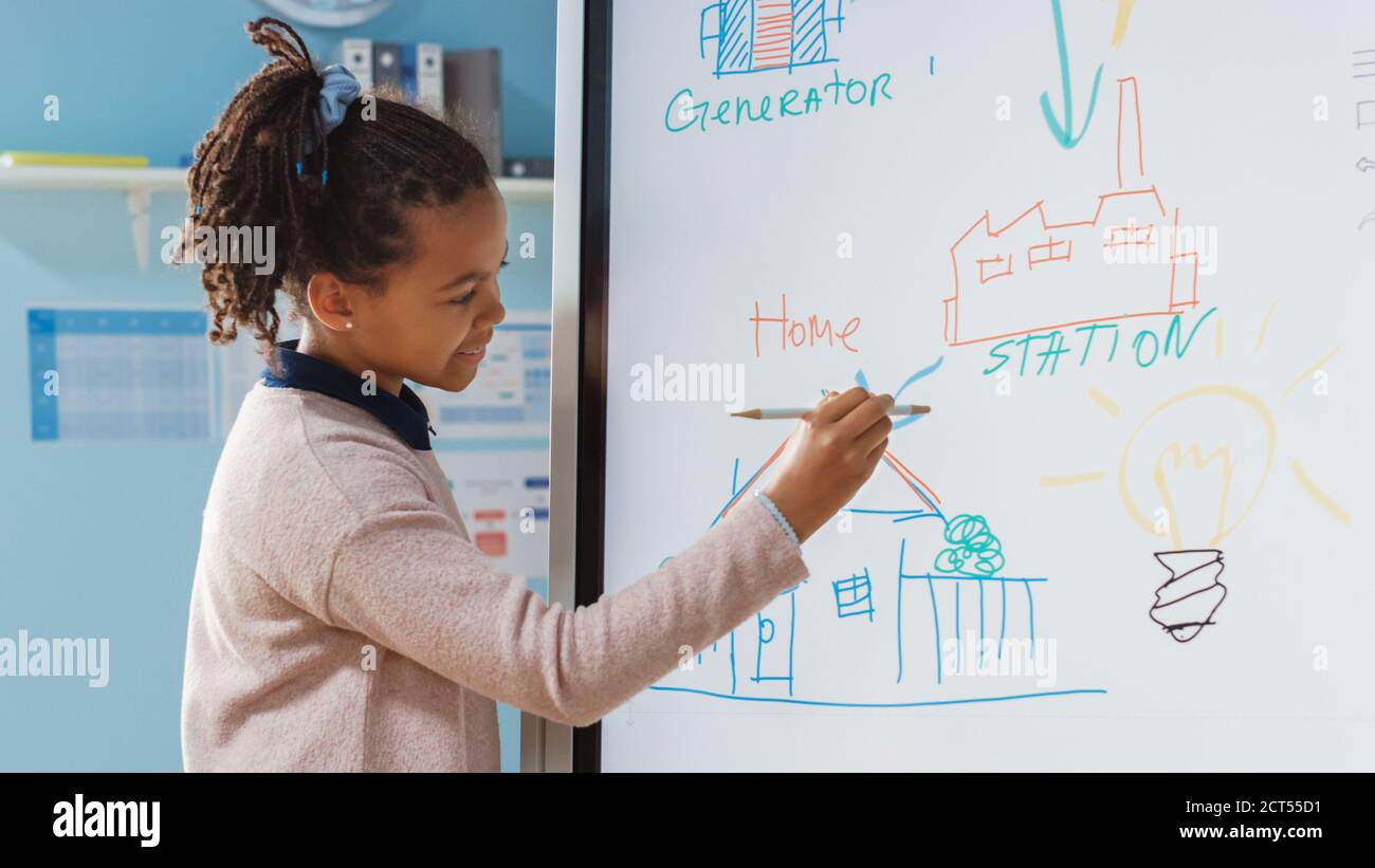 Classe di scienze della scuola elementare: Portrait of cute Girl utilizza  la lavagna interattiva digitale per mostrare a una classe completa come  funziona l'energia rinnovabile Foto stock - Alamy