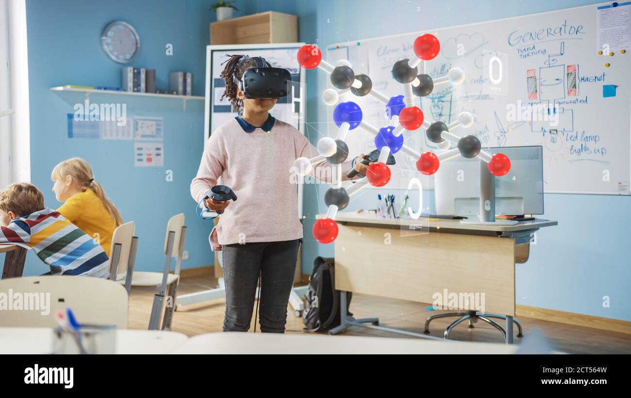 Cute Girl indossa le cuffie per realtà aumentata e utilizza i controller interagisce con 3D Molecule. Corso di scienze della scuola futuristica per i bambini che imparano dentro Foto Stock