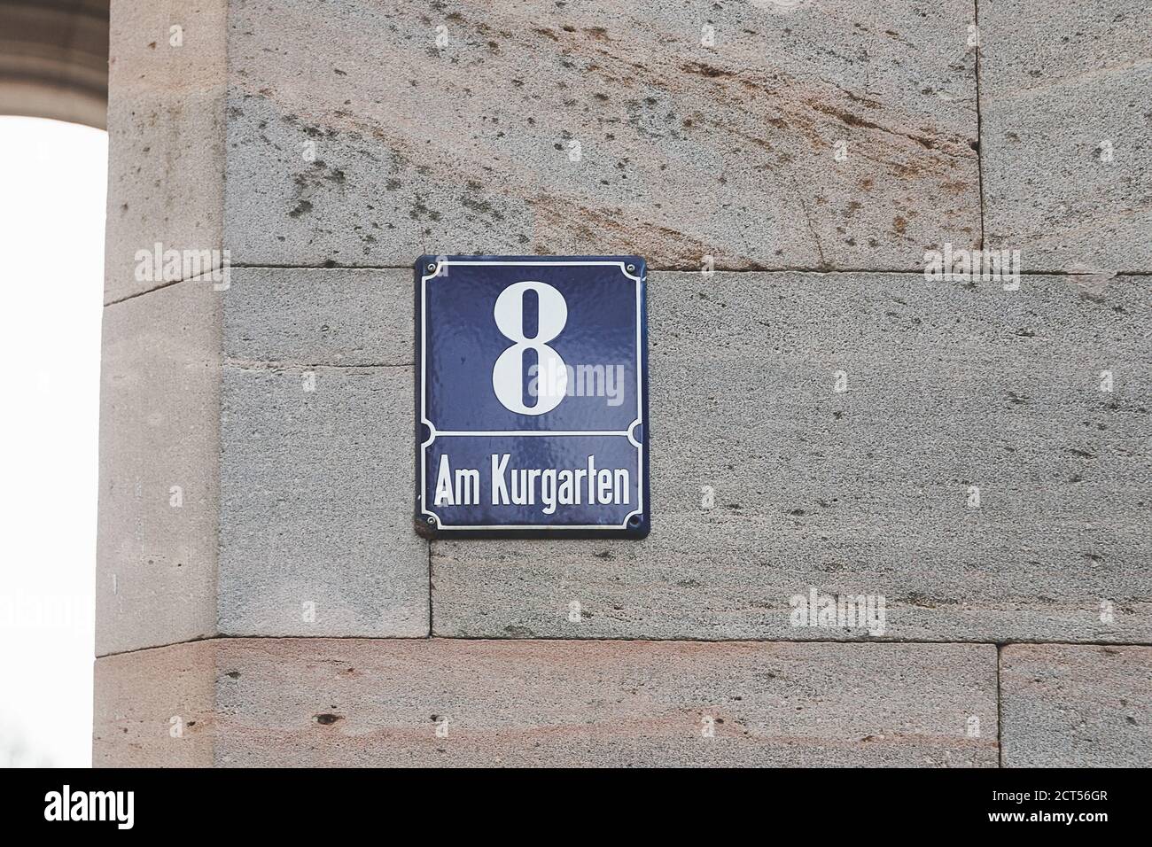 Am Kurgarten Via nome segno a Bad Kissingen, Germania. Un cartello con il nome di una strada è un cartello utilizzato per identificare le strade denominate, generalmente quelle che non sono qualif Foto Stock