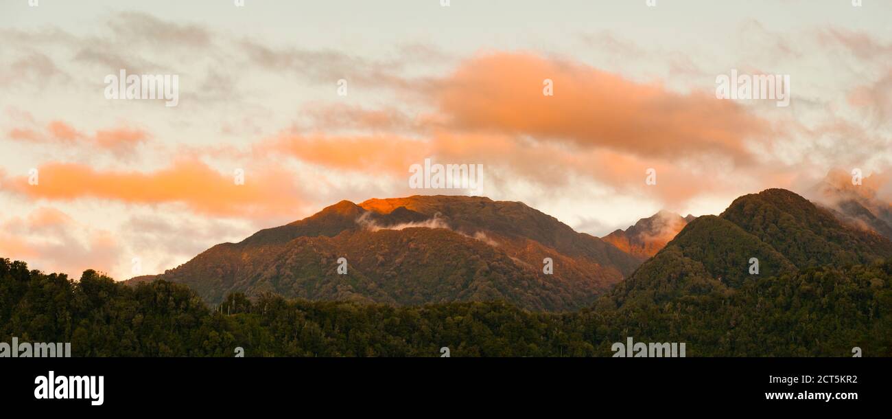 Foto panoramica del tramonto sulle montagne nel Parco Nazionale di Westland sulla costa occidentale dell'Isola del Sud, Nuova Zelanda Foto Stock