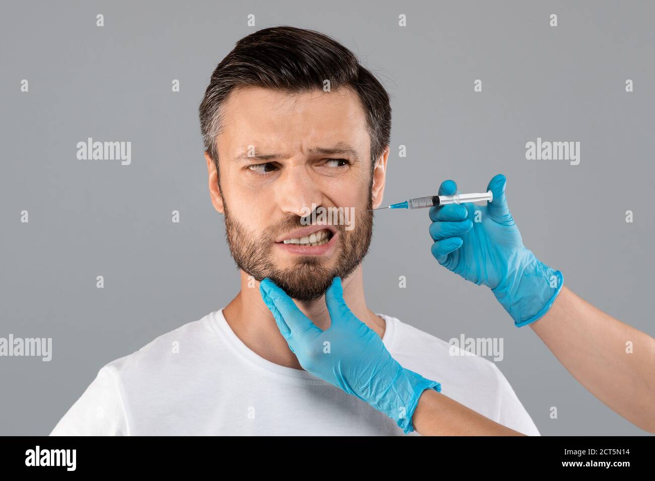 Uomo bearded che ottiene l'iniezione di bellezza in salone Foto Stock