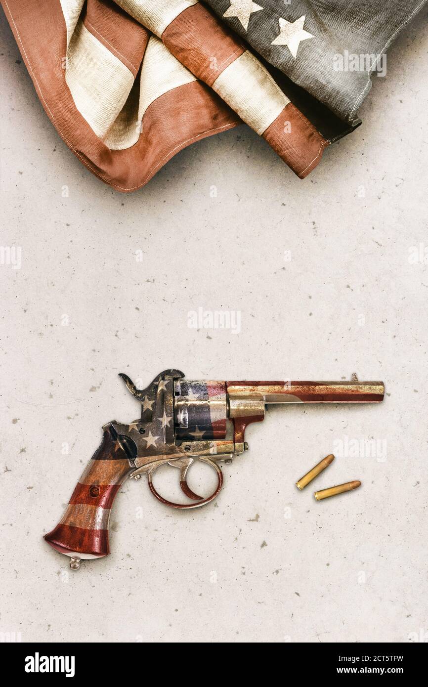 Antica pistola revolver con proiettili su uno sfondo concreto con Bandiera americana d'epoca Foto Stock