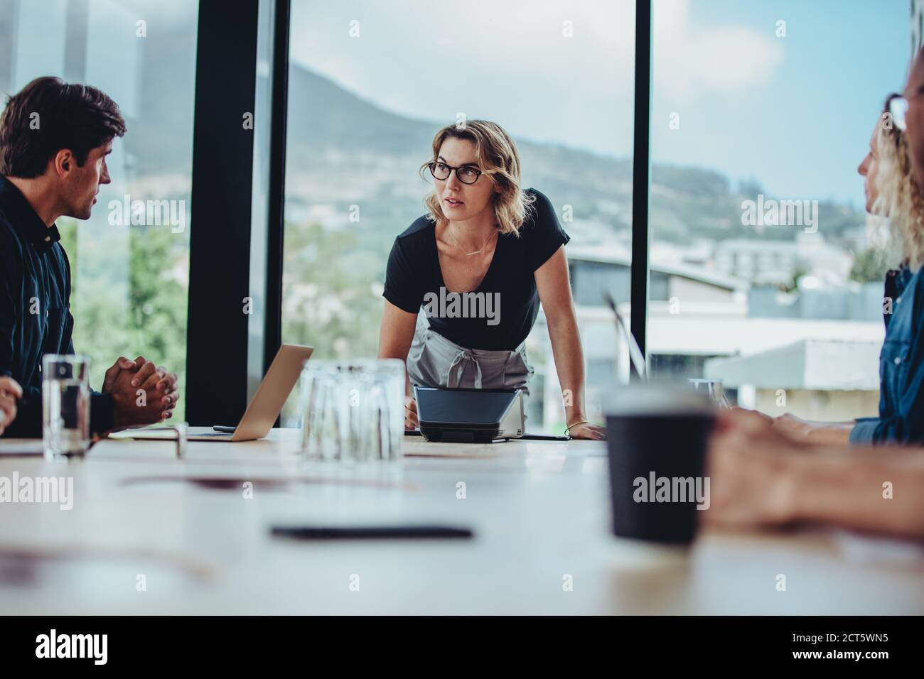 Donna che spiega le sue idee ai colleghi nella sala conferenze. donna d'affari che spiega ai colleghi il progetto in ufficio. Foto Stock