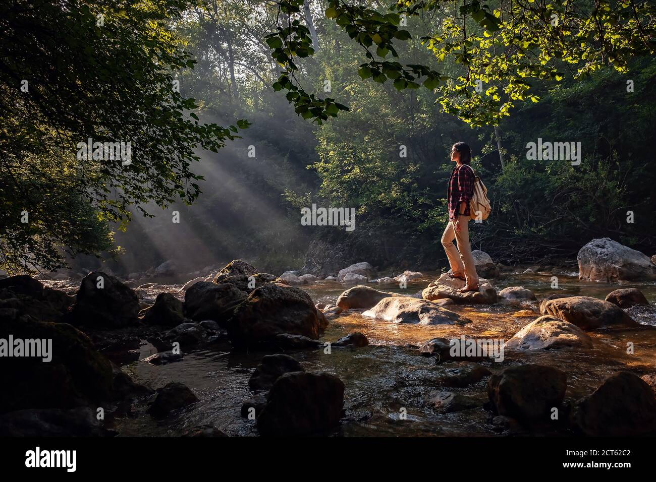 Una donna esplora luoghi nuovi, magici e fantastici in tutto il mondo, circondati dalla natura e diffondendo le braccia per respirare e rilassarsi. Donna escursionista c Foto Stock