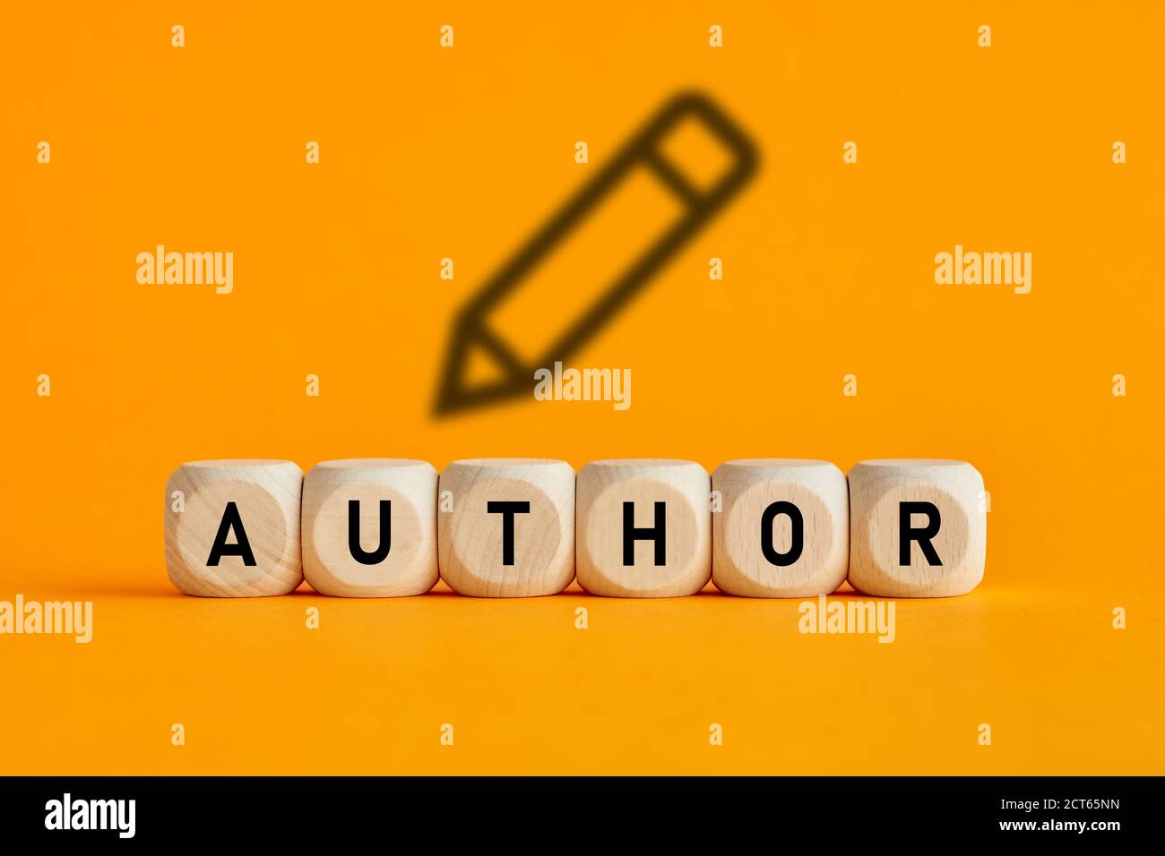 La parola autore scritto su cubetti di legno con icona a matita su sfondo giallo. Concetto di autore, scrittura o narrazione. Foto Stock