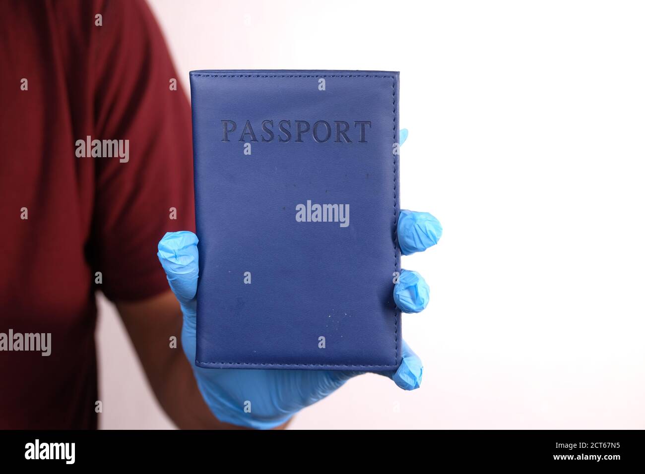 indossare guanti chirurgici blu con passaporto in mano. Foto Stock