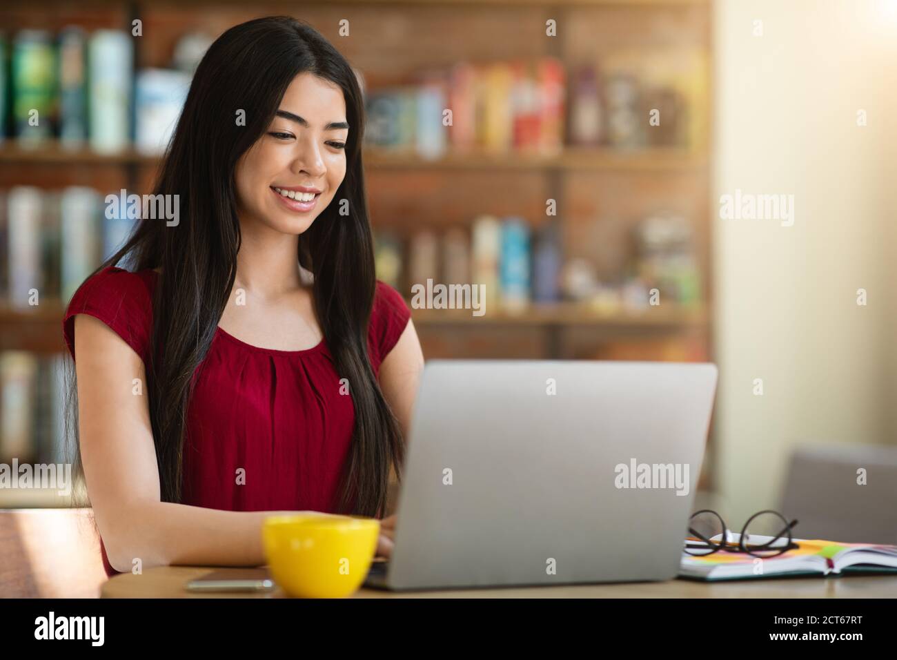 Siti Web di ricerca di lavoro. Giovane donna asiatica usando il laptop nel caffè, verificando le offerte di lavoro Foto Stock