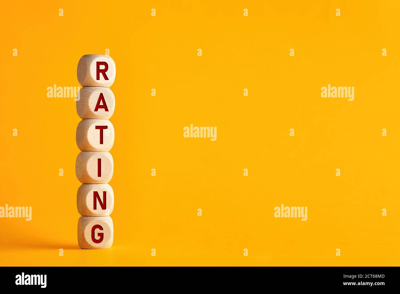La parola rating su cubi di legno su sfondo giallo. Miglioramento della valutazione del servizio e del concetto di valutazione del cliente. Foto Stock