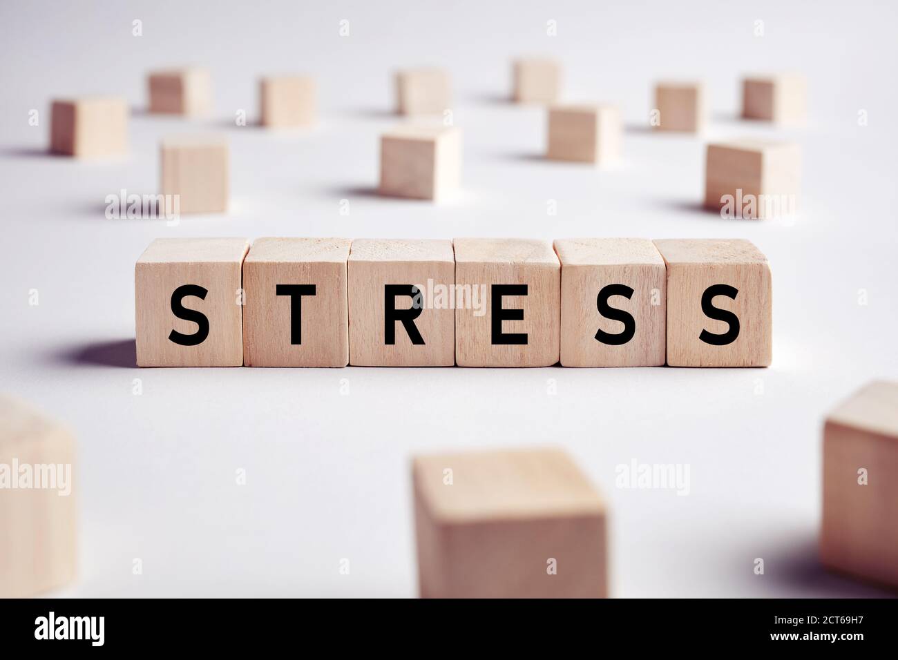 La parola stress su blocchi di legno su sfondo bianco. Stress sul luogo di lavoro o concetto di vita quotidiana. Foto Stock