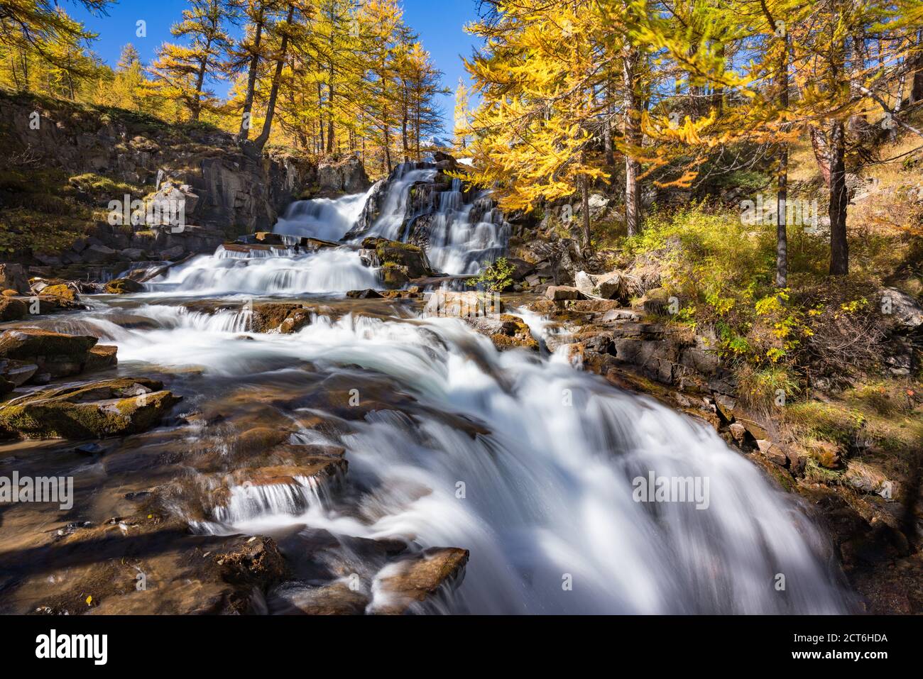 Cascata Fontcouverte in autunno con larici nella Valle alta di Caree. Nevache, Alte Alpi (05), Alpi, Francia Foto Stock