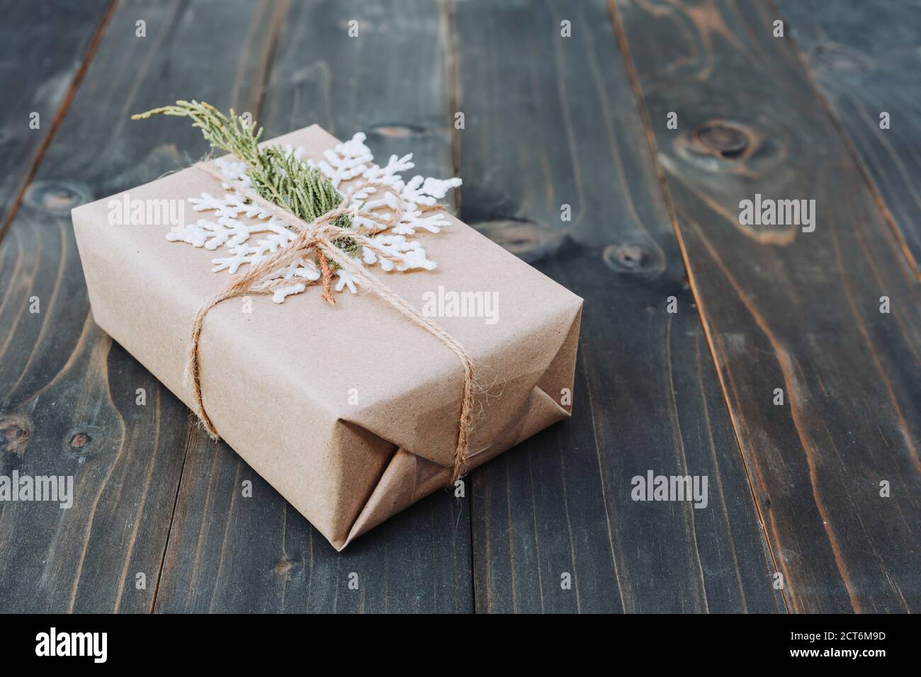 Stringa o spago legato in un arco sulla carta kraft. Beown confezione regalo su legno con lo spazio. Foto Stock