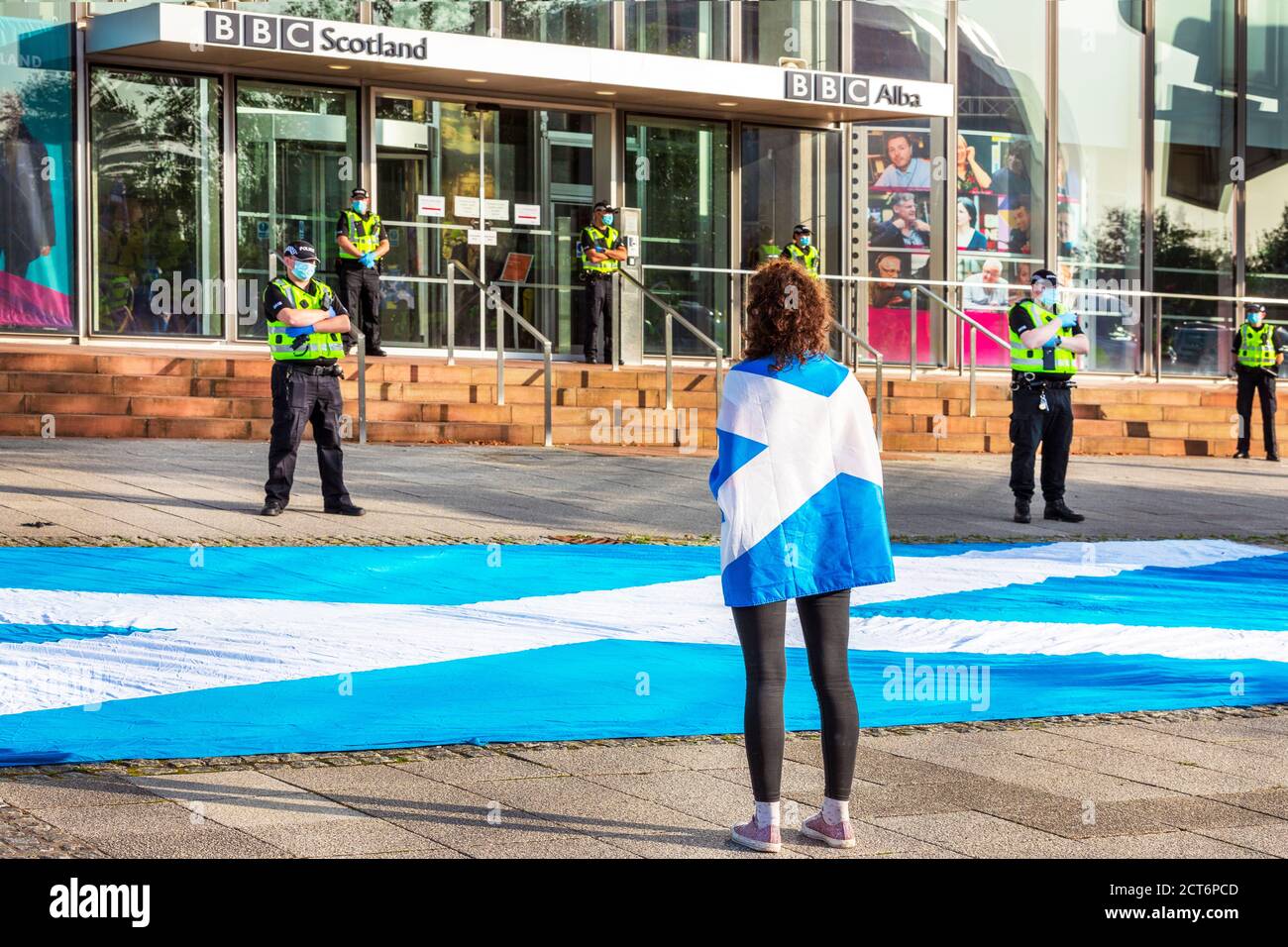 Donna che indossa una bandiera scozzese come segno per l'indipendenza e che protesta al di fuori della sede scozzese della BBC a Pacific Quay, Glasgow, Scozia, Foto Stock