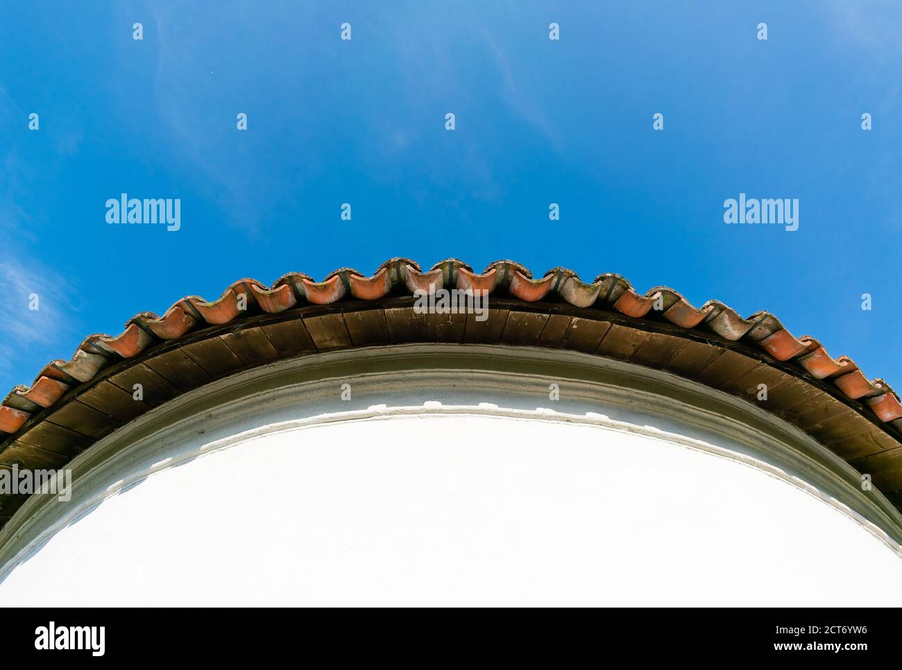Vista dal basso del bordo di una piastrella circolare tetto su cielo blu Foto Stock