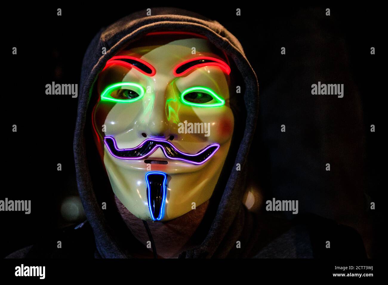 Attivista in maschera illuminata 'V or Vendetti' Guy Fawkes a Million Masks marzo dal gruppo hacktivist Anonymous, Guy Fawkes Day, Londra, UK Foto Stock