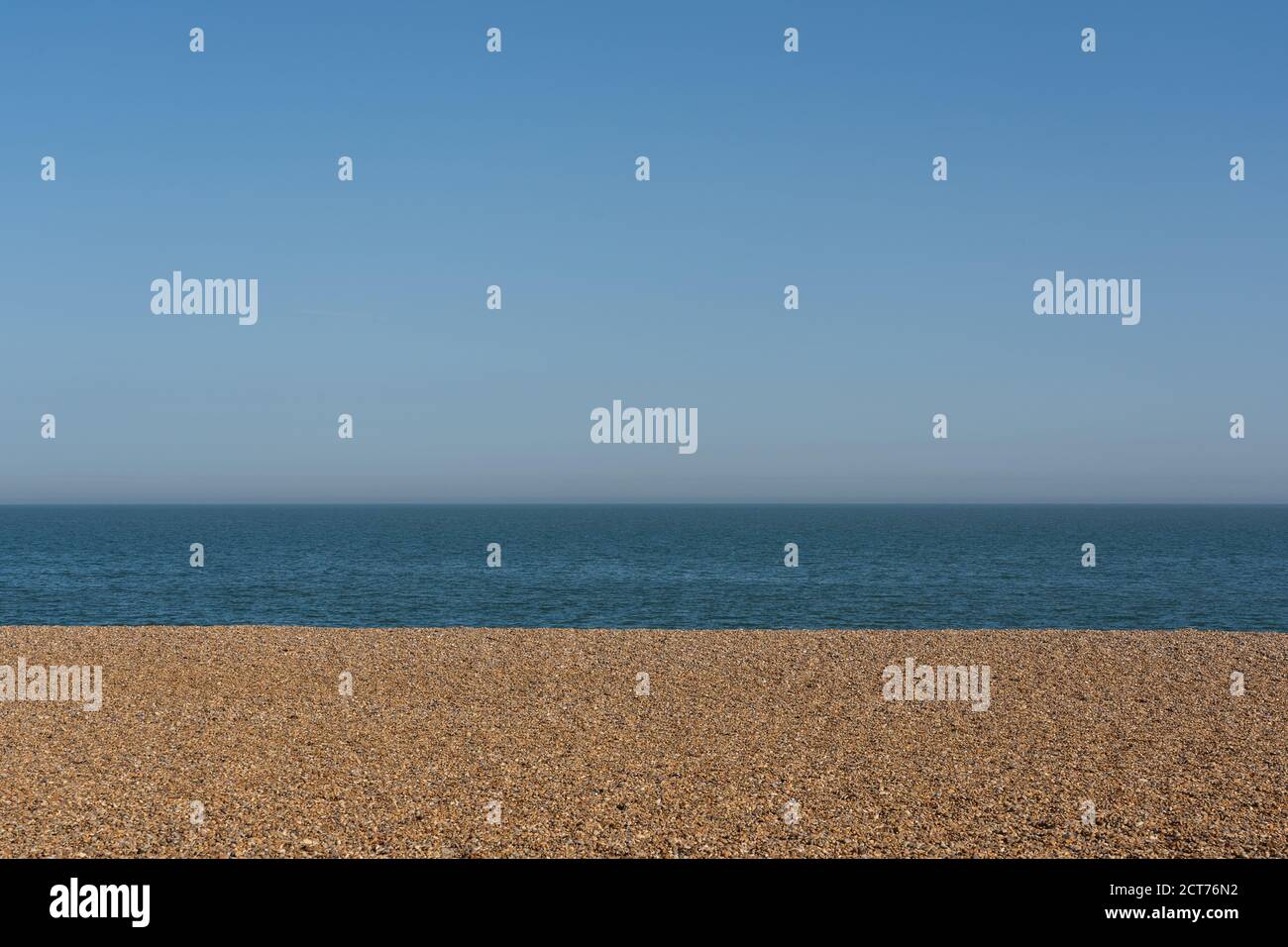 Spiaggia vuota di ghiaia con cielo blu chiaro e mare. Aldeburgh Beach, Aldeburgh, Suffolk. REGNO UNITO Foto Stock