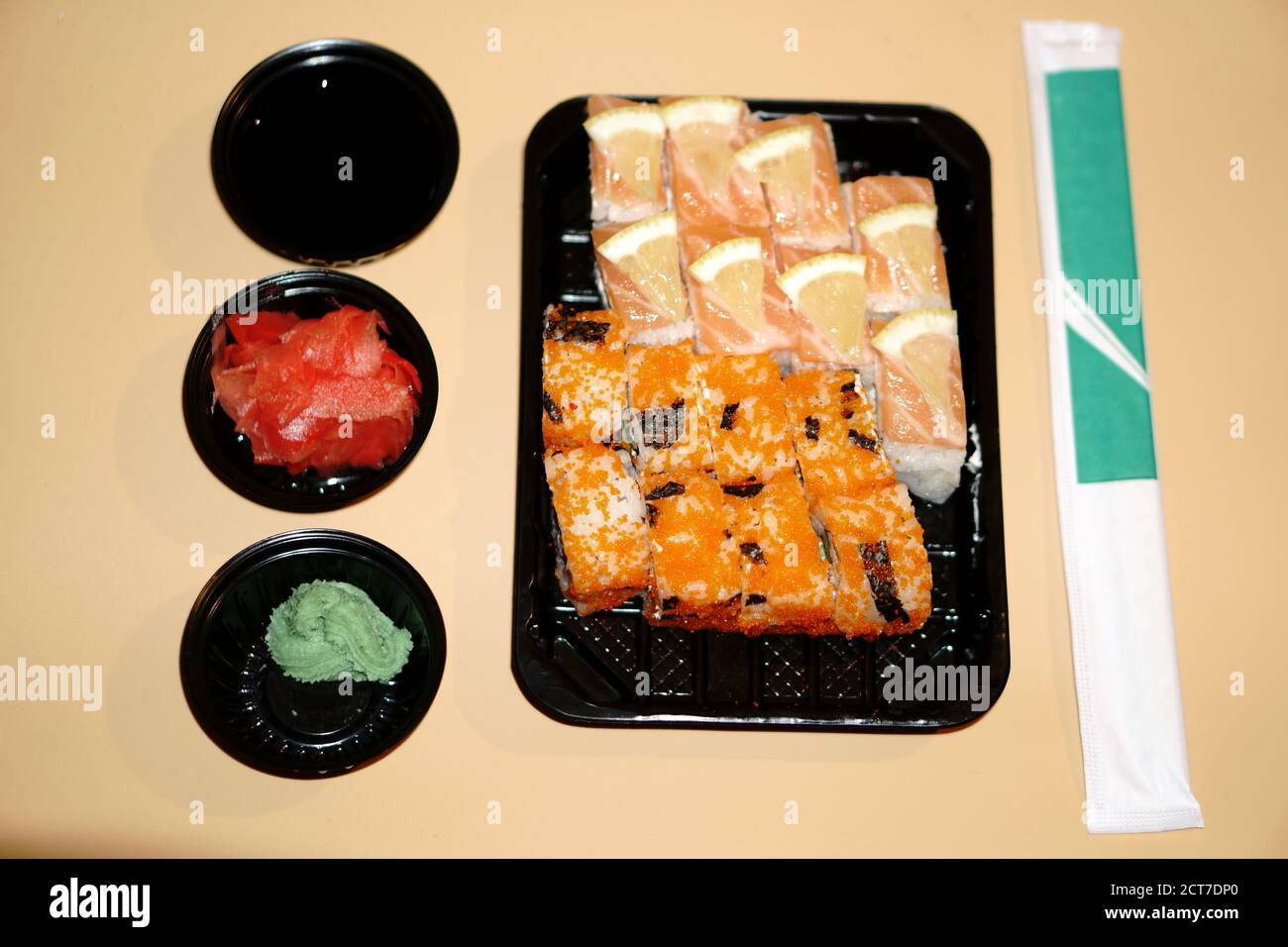Panini sushi in un contenitore di plastica e spezie extra in un recipiente di plastica Foto Stock