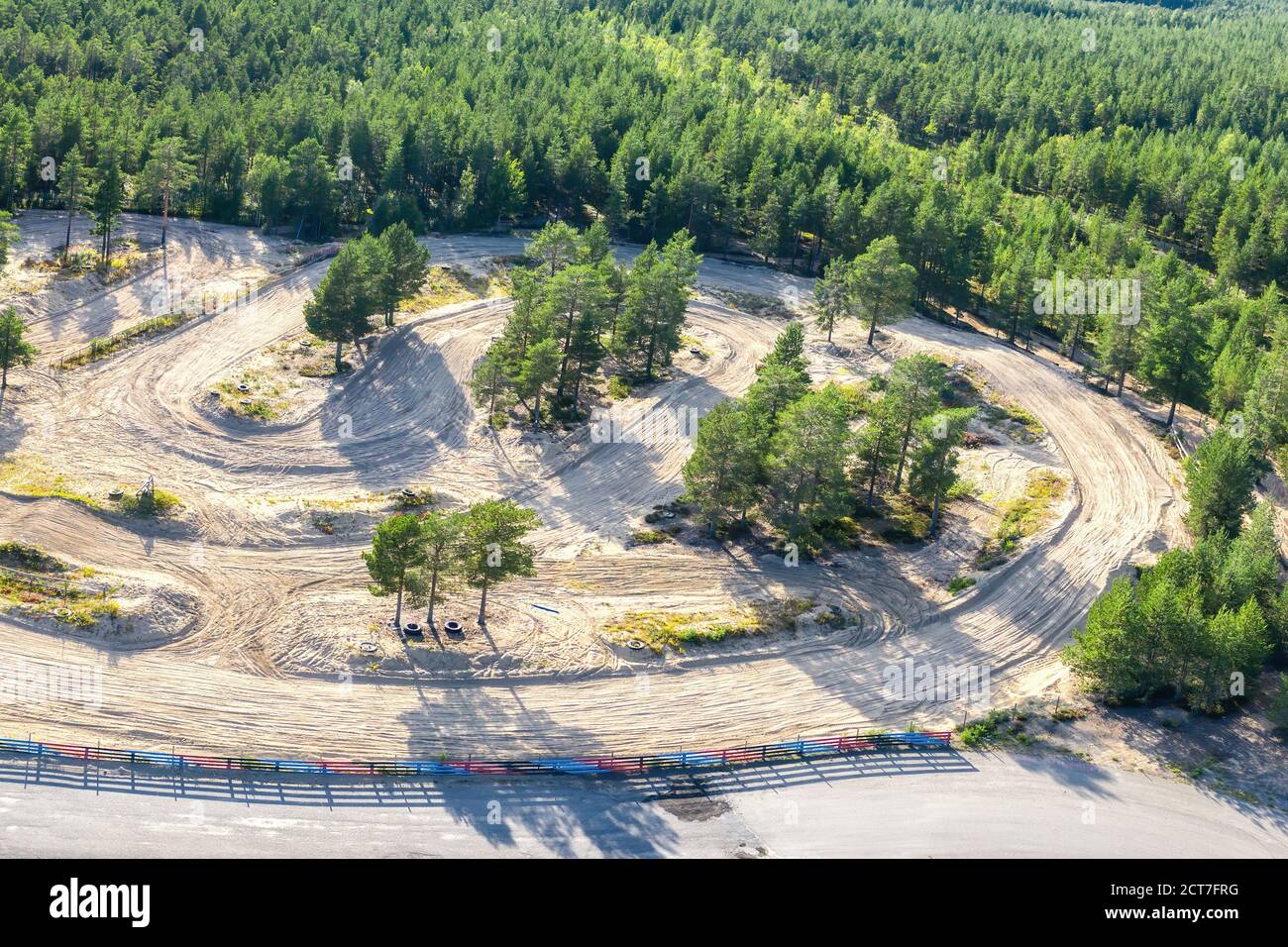 Vista aerea mozzafiato di una parte del circuito di allenamento speedway e della foresta di pini verdi scandinavi intorno. Giorno estivo soleggiato. Tipico Scandin del Nord Foto Stock
