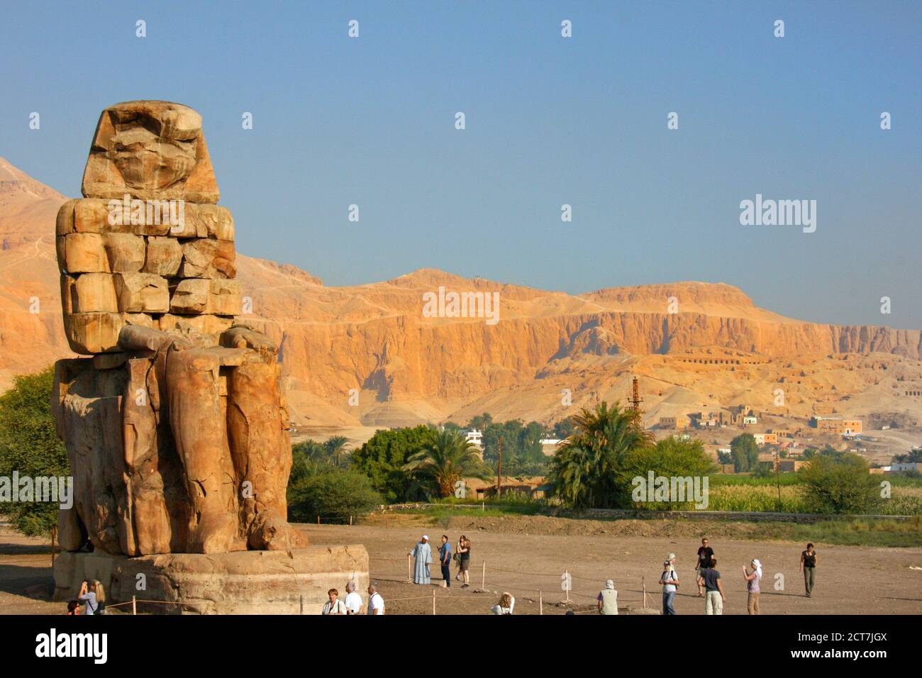 Egitto - 2013, Colossi di Memnon in Egitto con le montagne sullo sfondo e i turisti godendo la vista Foto Stock