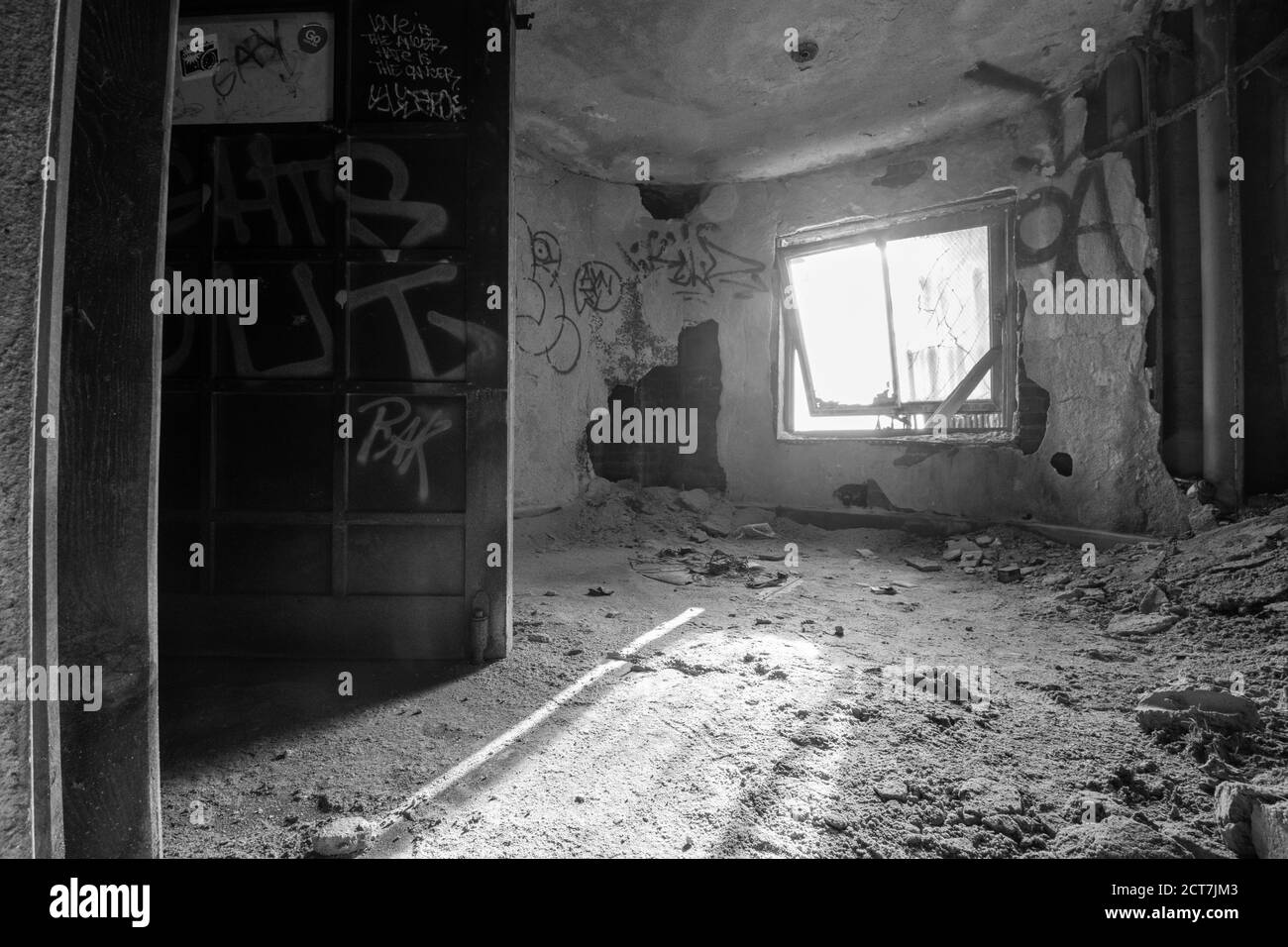 Una vecchia finestra in un edificio abbandonato pieno di polvere E detriti con luci che brillavano Foto Stock
