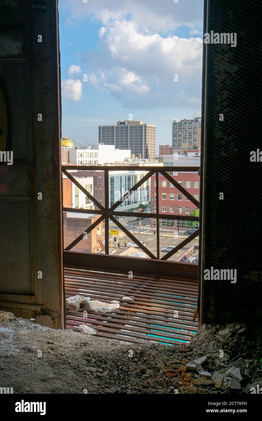 Si affaccia su una porta aperta in un vecchio edificio abbandonato In uno skyline della città Foto Stock