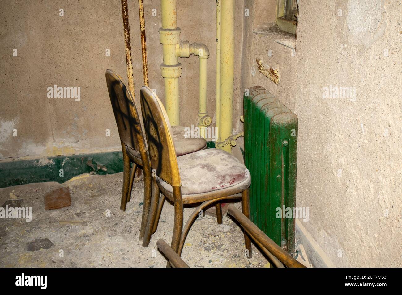 Due sedie coperte di polvere e detriti all'interno di un vecchio E l'edificio abbandonato Foto Stock