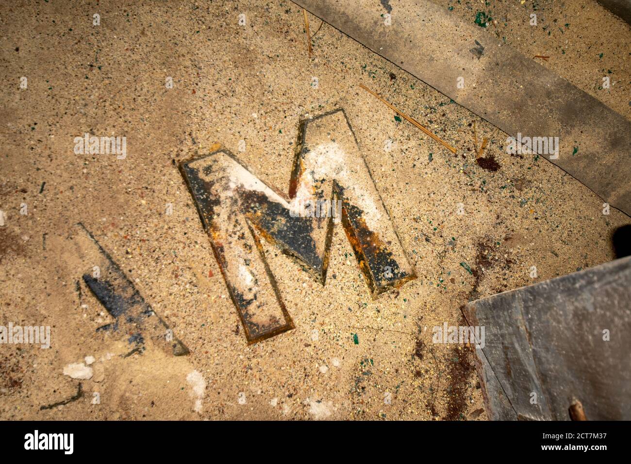 La lettera M da un segno in un vecchio abbandonato Posa di edifici in polvere e detriti Foto Stock