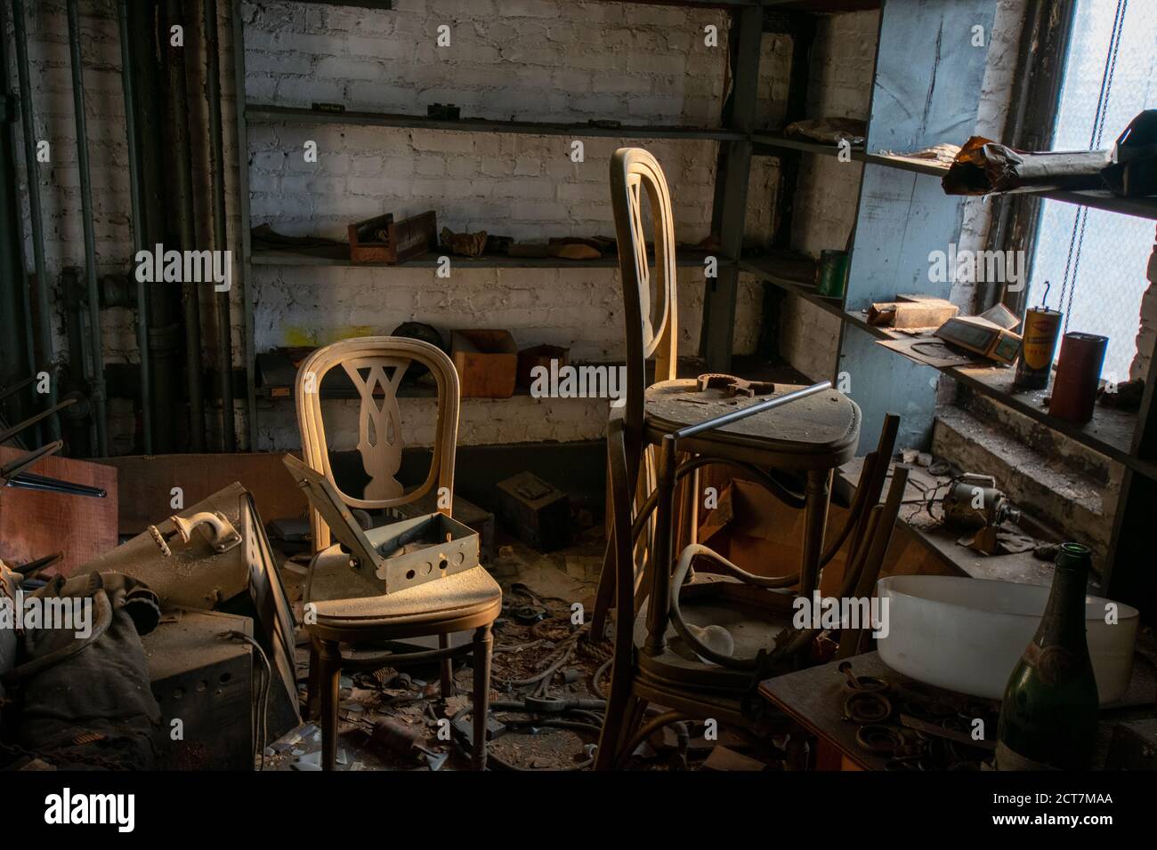 Una Camera Vecchia in un edificio abbandonato con due sedie Pieno di detriti e Cestino Foto Stock