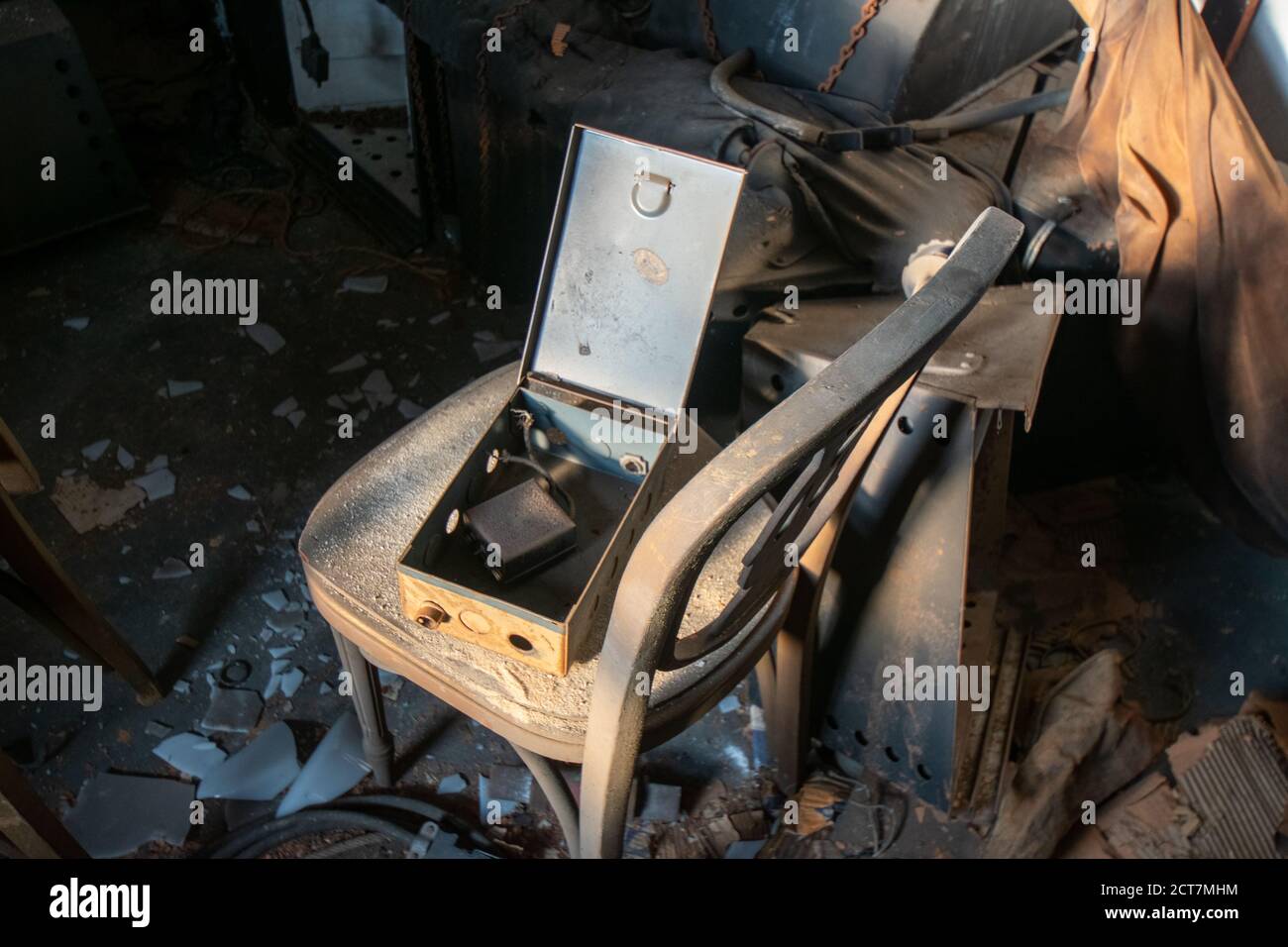 Una vecchia cassetta di sicurezza su una sedia antica in un abbandonato Edificio pieno di detriti Foto Stock