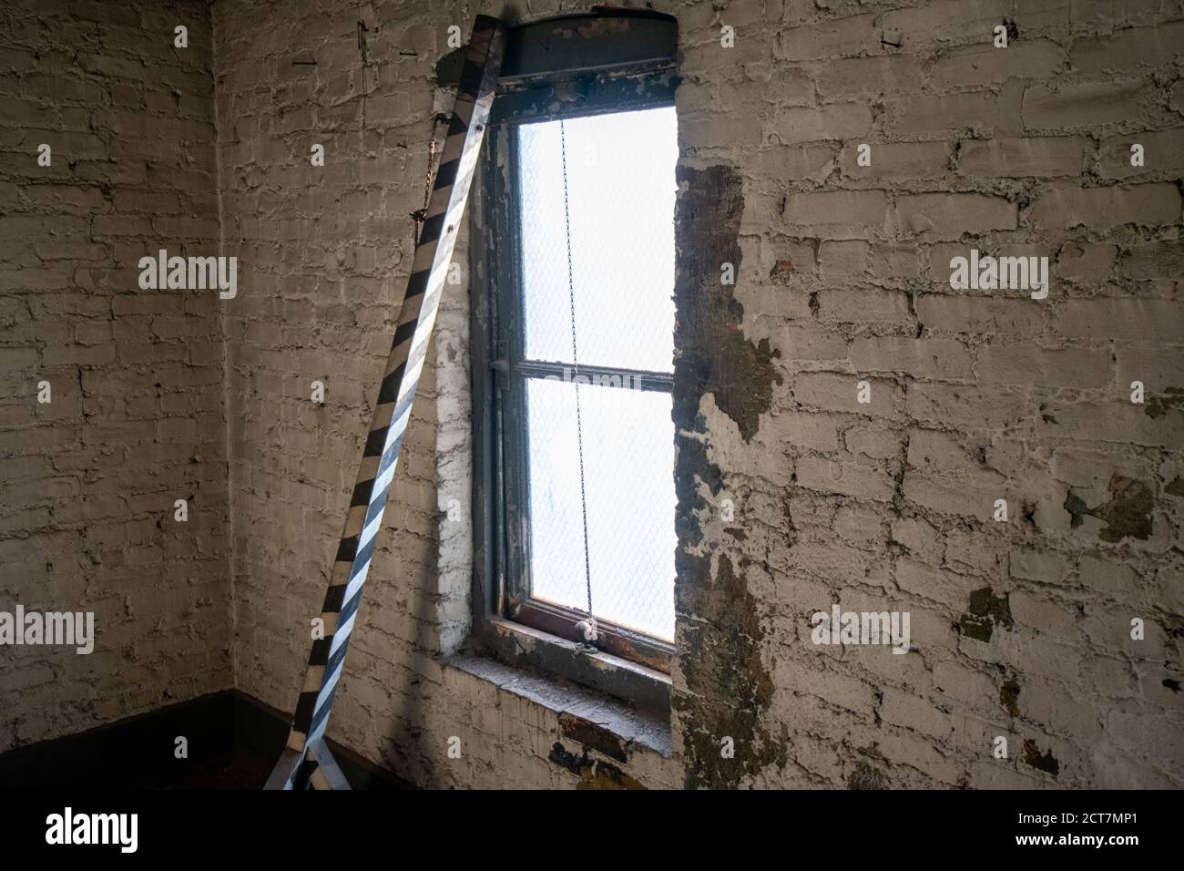 Una vecchia finestra che illumina una stanza in un Edificio abbandonato Foto Stock