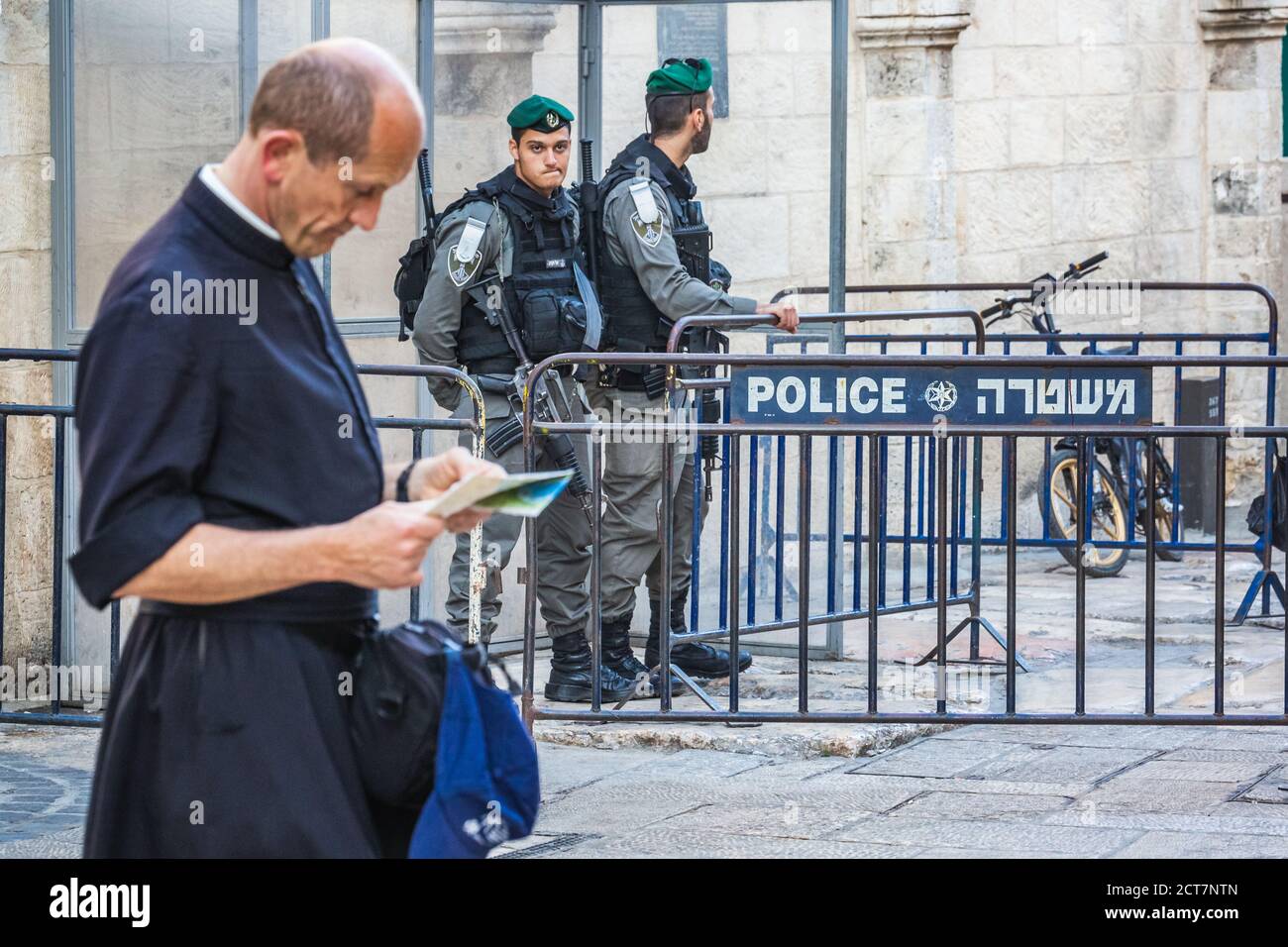Il sacerdote guarda la mappa e gli ufficiali di polizia in servizio vicino alla porta di Damasco nella città vecchia di Gerusalemme. Sono stati costruiti nel 16 ° secolo e sono un tipico Foto Stock