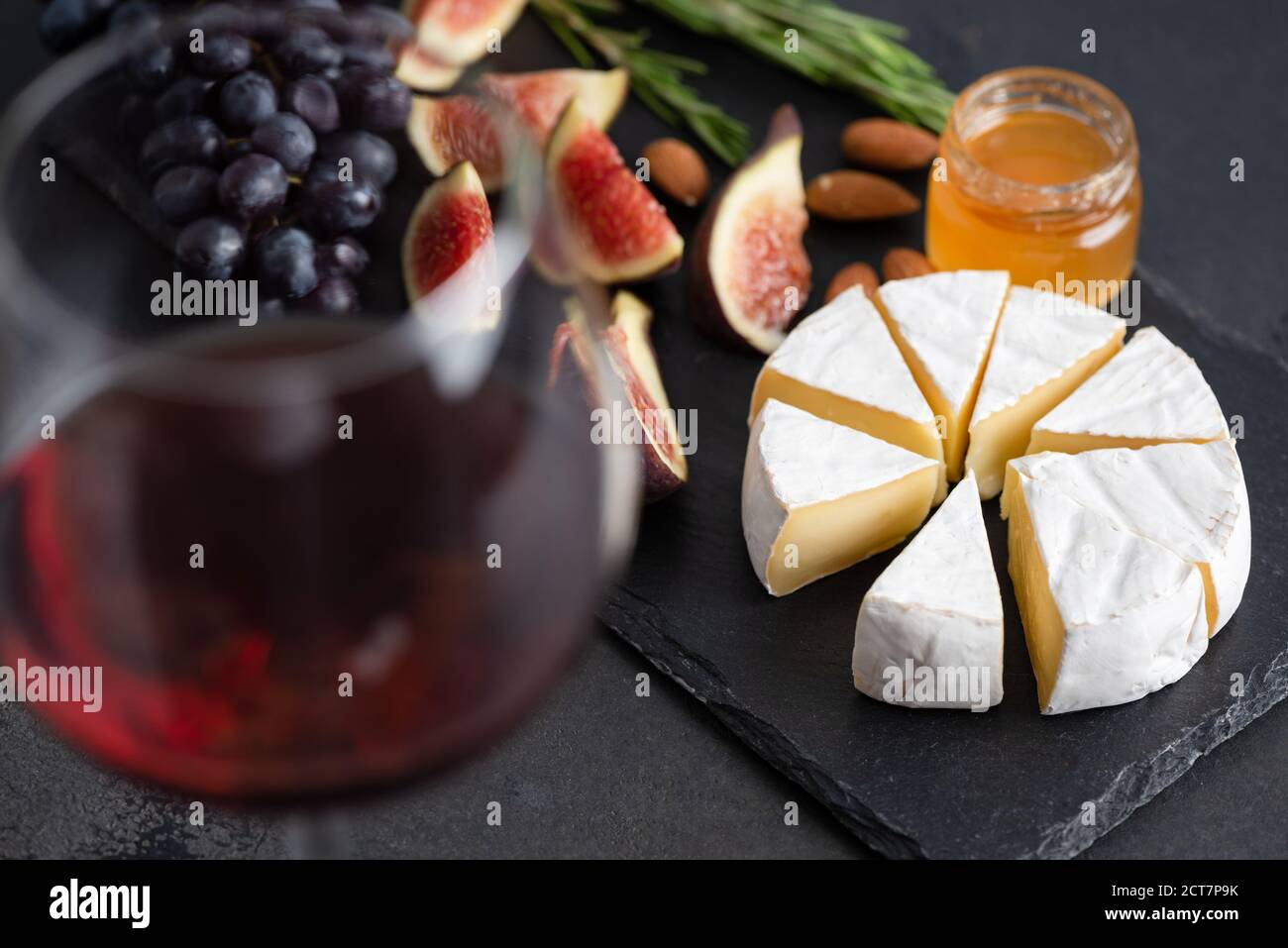 Vino, brie e fichi. Piatto antipasto con formaggio e bicchiere di vino rosso Foto Stock