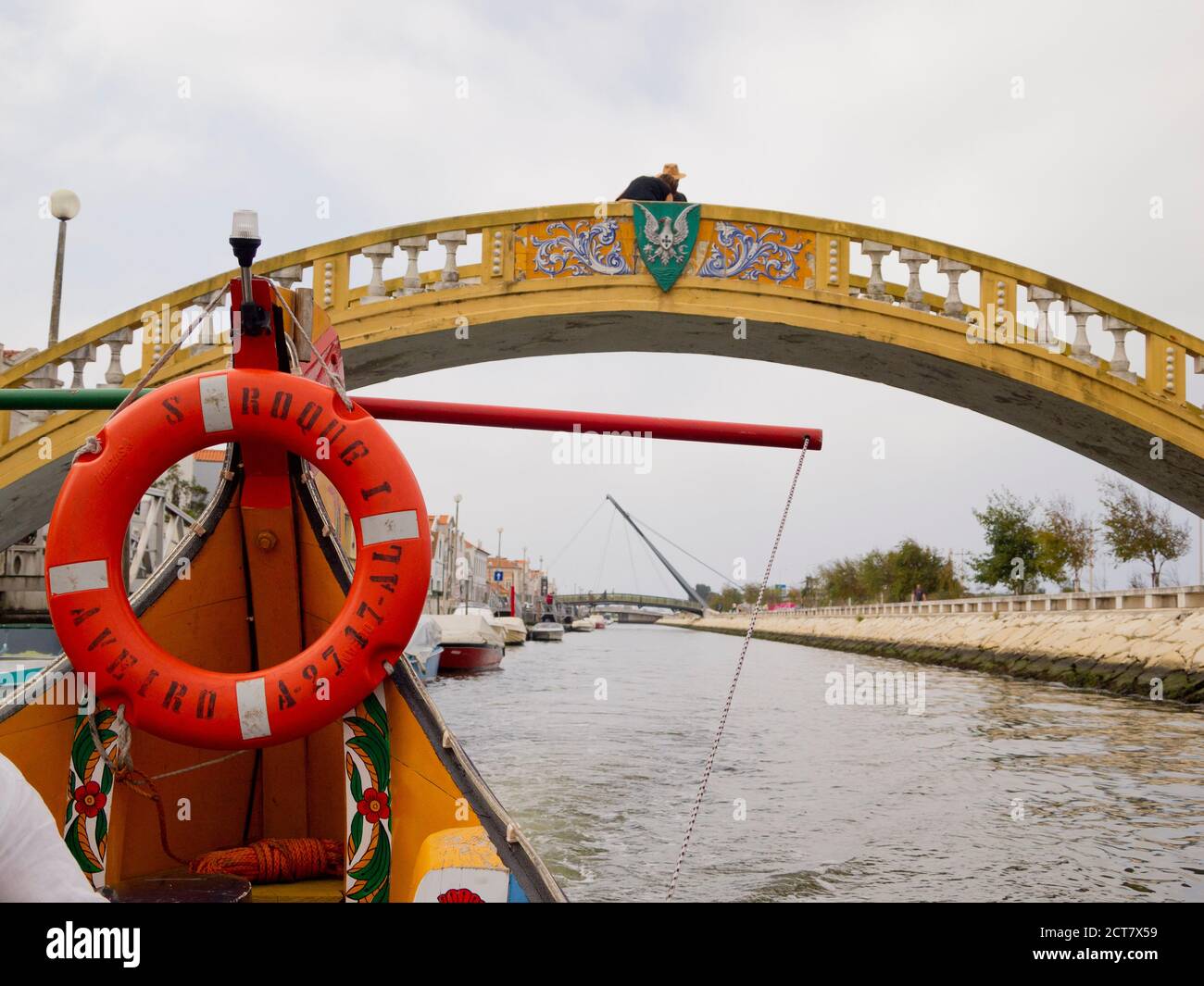 Tradizionale barca turistica Moliceiro passando sopra il ponte di Carcavelos sul canale di Sao Roque, Aveiro, Portogallo Foto Stock