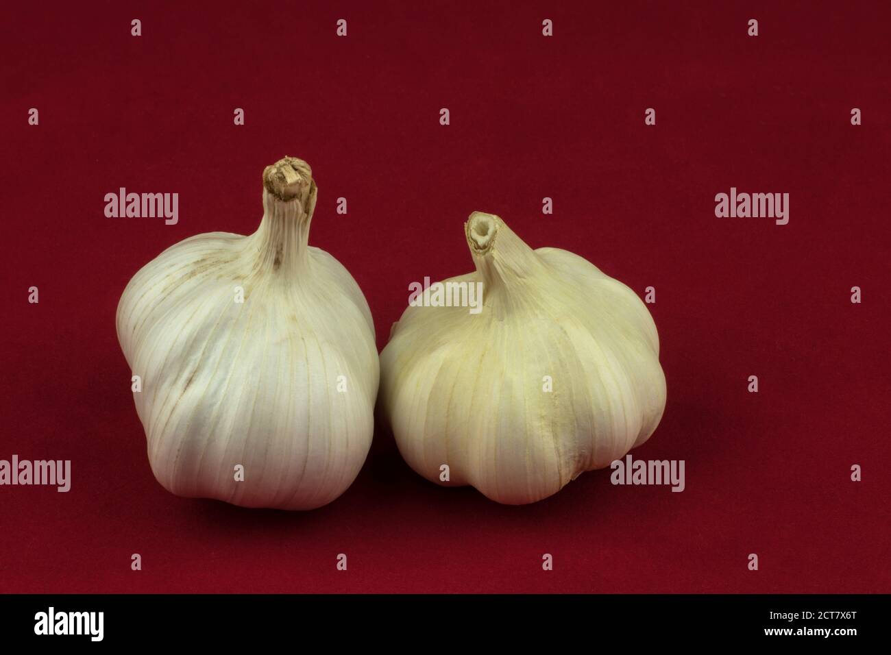 Bulbi di aglio isolati su sfondo rosso Foto Stock